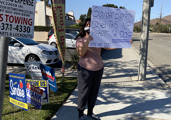 Local blogger protesting outside Everett's HQ with deceptive sign.